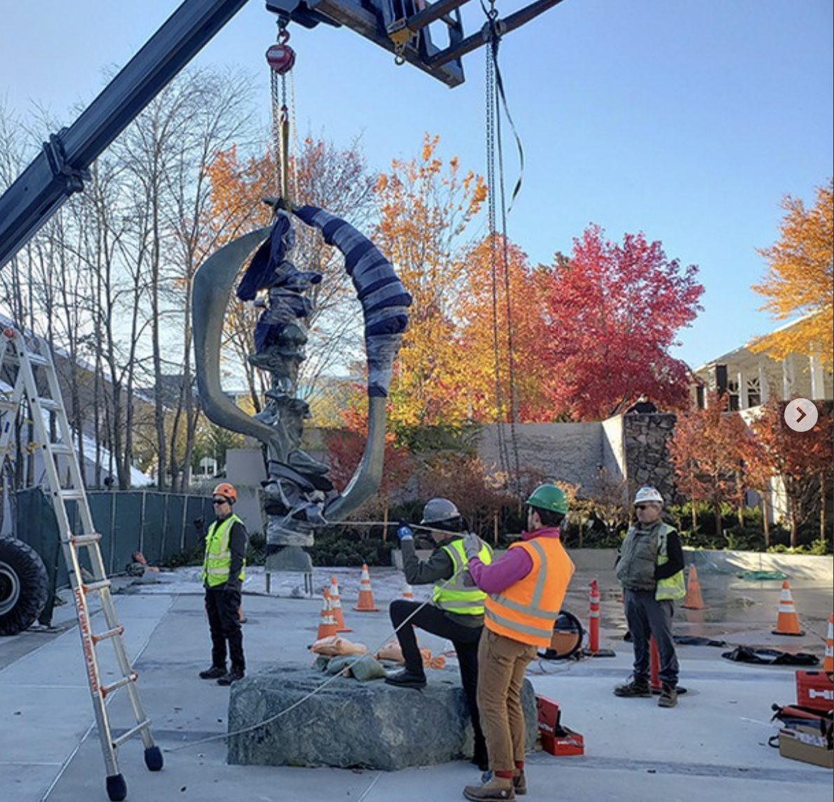 Crane lifting the Evolution of Man sculpture during renovation, fall 2022